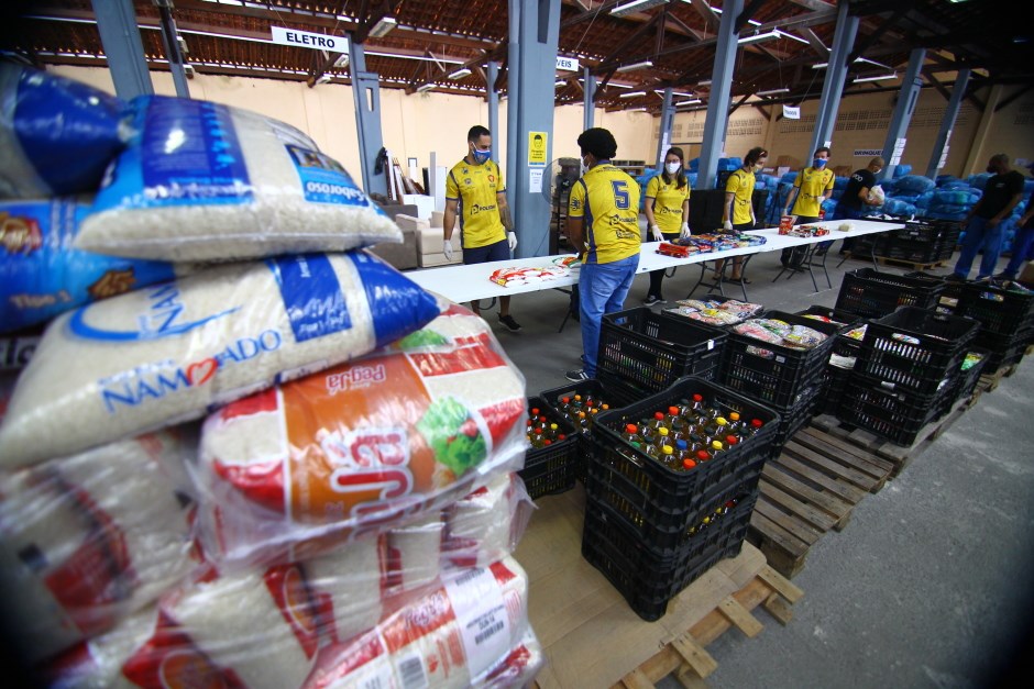 Atletas das equipes masculina e feminina do São José Rugby auxiliam na montagem dos kits de alimentos no Centro de Distribuição do Fundo Social de Solidariedade de São José. Foto: Claudio Vieira/PMSJC 30-03-2021 